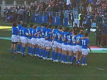 Photographie d'une équipe de rugby en ligne, portant des maillots bleus