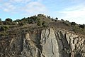 L'ermita al cim des del coll de la Vaca. La pedra de llicorella en un primer pla