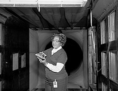 Black and white photograph of Mary Jackson holding a model in a wind tunnel