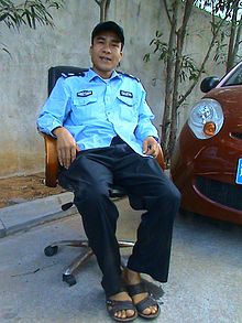 A security guard protecting the entrance to an apartment building, and managing the parking of cars in Haikou, Hainan Province, China Security guard in China 01.jpg