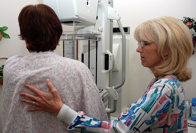 US Navy 080922-N-2688M-004 Lead Mammography Technologist Carmen Waters assists a patient