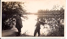 Dr. Karl Clark and guide Romeo Eymundson on the bank of the Athabasca River during one of Clark's oil sands expeditions, 1920s. From the Charles Eymundson fonds.