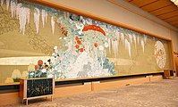 壁面装飾「麗花」は、日本画家の鹿見喜陌の下絵をもとに、綴織りの技法で織った織物で、39種類の日本の草花が織り込まれている。床に敷かれた緞通は、壁面装飾に描かれた「藤の花」が舞い散った様子を表現している。