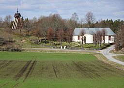 Mörkö kyrka och klockstapeln i Södermanlands odlingslandskap, 2017.