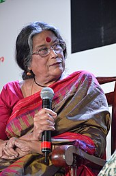 Nabanita Dev Sen sitzend, mit Mikrofon in der Hand