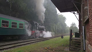 Un train vapeur quitte la gare.