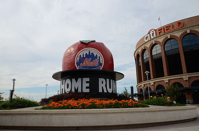 A sculpture of a red apple with the New York Mets logo on it rises above a black pedestal with the words "Home Run" in large letters.