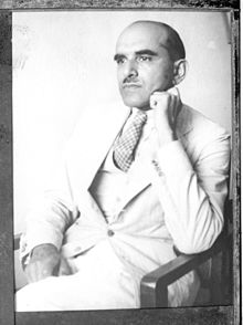 Black and white photograph of a man sitting in a chair.
