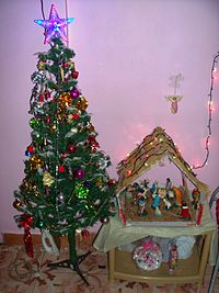 A nativity scene and a Christmas tree, two popular decorations displayed by Christians during Christmastide Christmas Crib.jpg