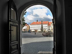 Výhled ze vrat kostela sv. Jana Křtitele na teplické Zámecké náměstí s morovým sloupem a hotelem Prince de Ligne v pozadí