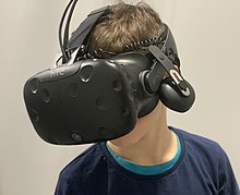 Some software platforms require a virtual reality headset to explore the metaverse. Un enfant portant un casque de realite virtuelle (Exalto, Villeurbanne).jpg