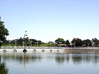 From the central part of Zhongnanhai across the Middle Sea, to the bridge that divides Zhongnanhai from Beihai Park, with the White Stupa of the Beihai Park seen in the distance