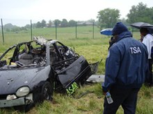 TSA officers view the post-blast remains of a Dodge Neon after an explosive was detonated inside it during training. 061509 story4.jpg