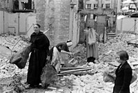 Menno Huizinga: Ženy si odnášejí dřevo na topení z rozbořené budovy během období nedostatku paliva způsobeného vnitrostátní železniční stávkou, Haag, 1944–1945