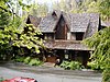 Photographie der Frontfassade des Oregon Caves Chateaus, umgeben von einem Wald, an einem feuchten Tag.