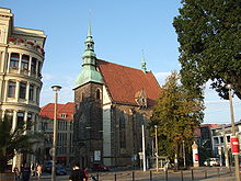 Barevná fotografie s pohledem na malý pozdně gotický kostel s věží