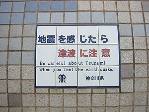 Tsunami warning sign on seawall in Kamakura, J...