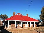 Building of square plan built of dolomite with a corrugated iron roof. The front and side elevation Type of site: Residency Previous use: Residential : Single. Current use: Military : Headquarters.