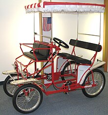 Surrey style rental quadracycle built by the International Surrey Company Red DX Surrey.jpg