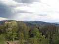 Hinter dem Rhyolith-Wachenberg (links) das Granit-Granitoid-Gebiet zwischen Weinheim (Geiersberg) und Schriesheim vom Hirschkopf aus, dahinter: Buntsandstein-Berge (Weißer Stein mit Turm[19]) nördlich Heidelbergs.