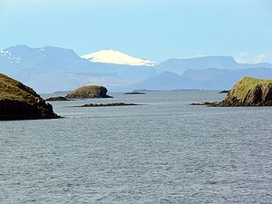 Insuloj en Breiðafjörður. Malproksime videblas la glaĉero Snæfellsjökull