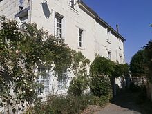 Photographie en couleurs d'une maison en tuffeau à étage.