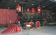 A gray steam locomotive with a 2-6-0 wheel arrangement (two leading wheels, six driving wheels, and no trailing wheels) and its tender