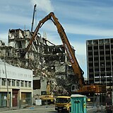 A high-reach excavator demolishing a building