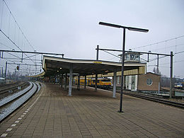 Perronniveau, midden een trein richting Weesp, uiterst rechts een sprinter uit de richting Utrecht.