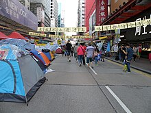 Straße mit Zelten, Plakaten und Menschen in Hongkong