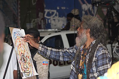 Nou la, da su aporte como pintor, en el carnaval de Port-au-Prince este 1 de marzo en el Champ-Mars. Fotografía Dade70