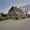 Boerderij onder een met riet en pannen gedekt wolfdak