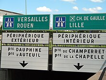 photo de panneaux de signalisation : Lille et périph intérieur à droite, Rouen et périph extérieur à gauche
