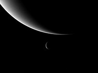 Photograph of the crescent planet Neptune (top) and its moon Triton (center), taken by Voyager 2 during its 1989 flyby