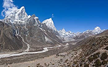 Vista panorâmica do vale de Khumbu Khola ao noroeste da vila Pheriche, nordeste do Nepal. À esquerda estão os picos Taboche (6 542 m) e Cholatse (6 440 m). Pheriche está situada a uma altitude de cerca de 4 371 m, acima do rio Tsola. É uma parada popular para caminhantes e alpinistas. Há um hospital rudimentar na vila que é operado sob os auspícios da Associação de Resgate do Himalaia (HRA), com sede em Catmandu. O hospital está aberto apenas durante as duas temporadas de trekking/escalada (março – maio ​​e outubro – dezembro). Embora o hospital tenha sido construído com apoio japonês em 1975, é composto por nepaleses e médicos voluntários que são principalmente dos Estados Unidos, Europa, Canadá e Austrália. Pheriche era principalmente uma vila agrícola que cultivava batatas e trigo-sarraceno e mantinha iaques. No entanto, agora no verão, muitos de seus homens são empregados por caminhantes como guias e carregadores. Há também muitos alojamentos onde os caminhantes e alpinistas a caminho do Acampamento Base do Monte Everest podem ficar. É uma importante parada de aclimatação. (definição 3 840 × 2 400)