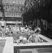 Butlins holiday camp in Pwllheli, Wales in the 1950s. Holiday camps symbolised the newfound prosperity and leisure of postwar Britain. Butlins holiday camp in Pwllheli (14998200805).jpg