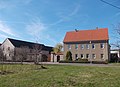 Wohnhaus, Scheune, Seitengebäude, Hofpflasterung, Vorgarten und Einfriedung mit Toranlage (Pforte) eines Bauernhofes