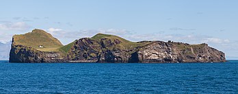 Elliðaey é uma das Ilhas Vestman e a terceira maior ilha da Islândia com uma área de 0,45 km2. Acredita-se que tenha se formado por uma erupção vulcânica submarina cerca de 5 ou 6 mil anos atrás. A ilha é desabitada e a pequena construção visível na imagem é uma cabana de caça construída em 1953. A ilha é de propriedade privada e administrada pela Associação de Caça Elliðaey. É acessível através de uma corda em seu lado inferior leste, por onde se chega de barco. (definição 5 583 × 2 190)