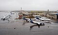 Flugfeld des Flughafens Talagi. Wohngebäude des Talaschski Awiagorodok im Hintergrund