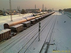 Het station gezien uit het westen, links achter de treinen op het opstelterrein het ronde metrostation, rechts de doorgaande sporen waarlangs de huidige perrons liggen.