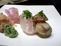 A seafood appetizer with a smoked baby scallop on the far right