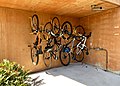 Sykler hengende på høykant i et veggstativ