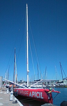 Vu de trois quarts face, en entier, voilier rouge amarré au ponton.