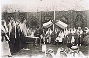 Another large group photo, with some people standing and others seated