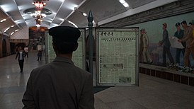Житель КНДР читает номер газеты на станции метро «Пухын»