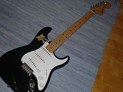 Pickguard de grande taille (blanc) sur une guitare Squier Stratocaster.