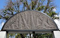 A syenitic block above the entrance with a symbol of shattered trees.