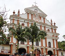photo de la façade d'une église blanche, de style baroque, avec des parements rouges