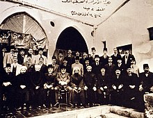 Large group of men—some seated, some standing