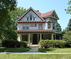 Ornamented, two-and-a-half story frame house with a full-width porch
